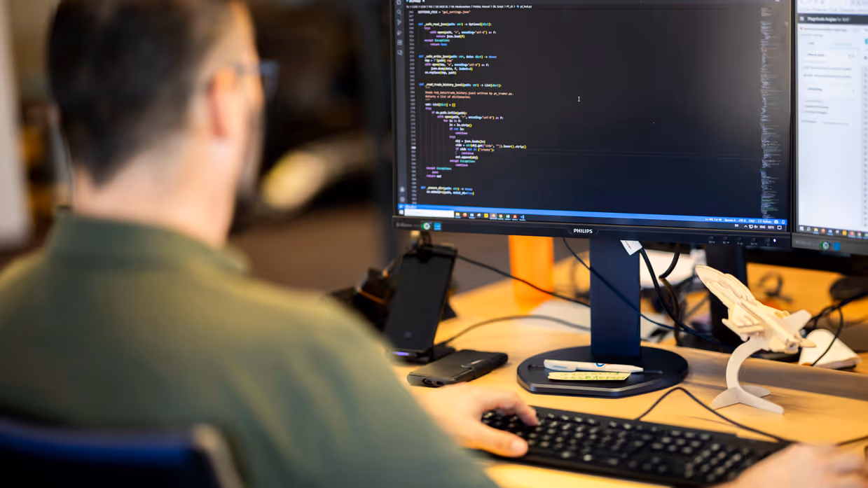 Marcel op de rug gefotografeerd terwijl hij naar z’n scherm kijkt.