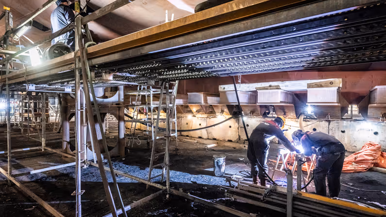 Alttekst: Lassers werken aan de staalconstructie van Zr.Ms. Holland.