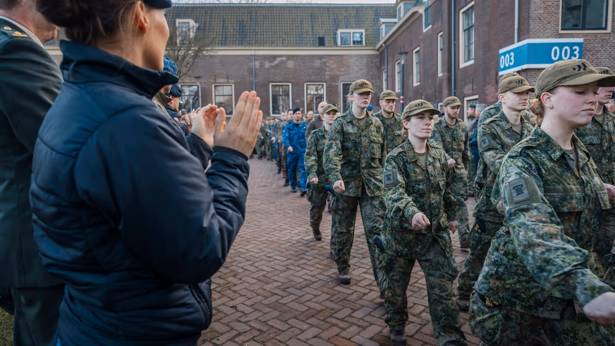 Militairen van de NWT marcheren langs klappende militairen.