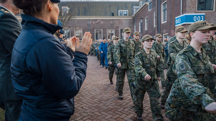 Militairen van de NWT marcheren langs klappende militairen.