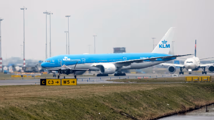 Een taxiënde F-35, met op de achtergrond een blauw passagierstoestel van KLM.