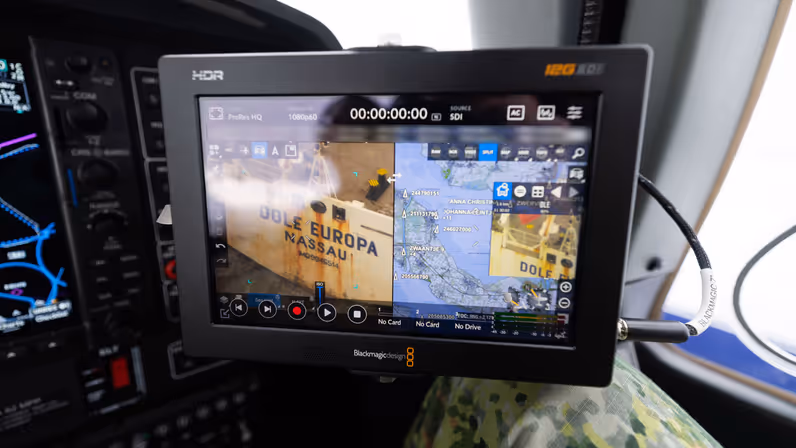 Missieconsole in het patrouillevliegtuig met live camerabeeld en kaartinformatie tijdens een vlucht.