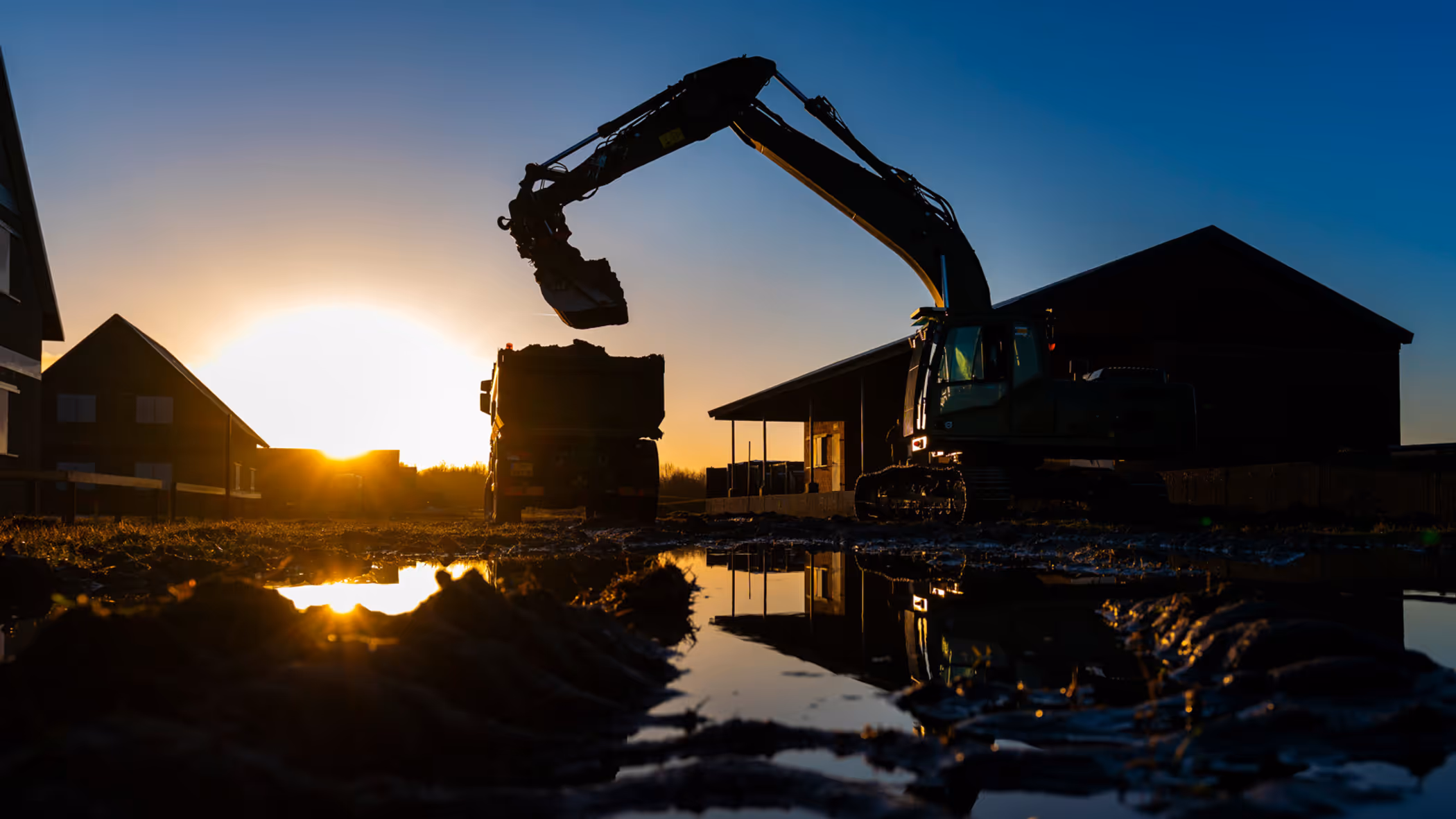 Een station, vrachtwagen en een spoor in aanbouw.