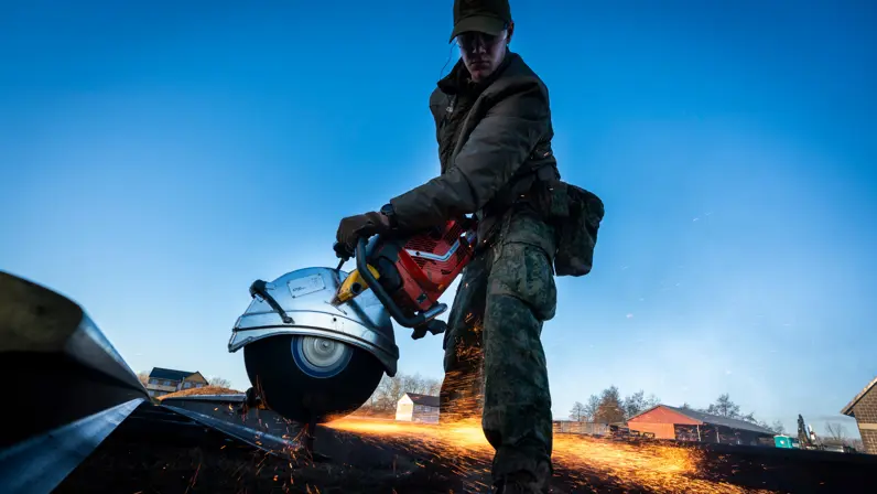 Een constructiegenist bewerkt een oude spoorstaaf.
