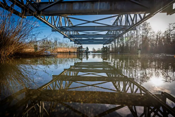 De constructiegenie legt een brug aan over het water.