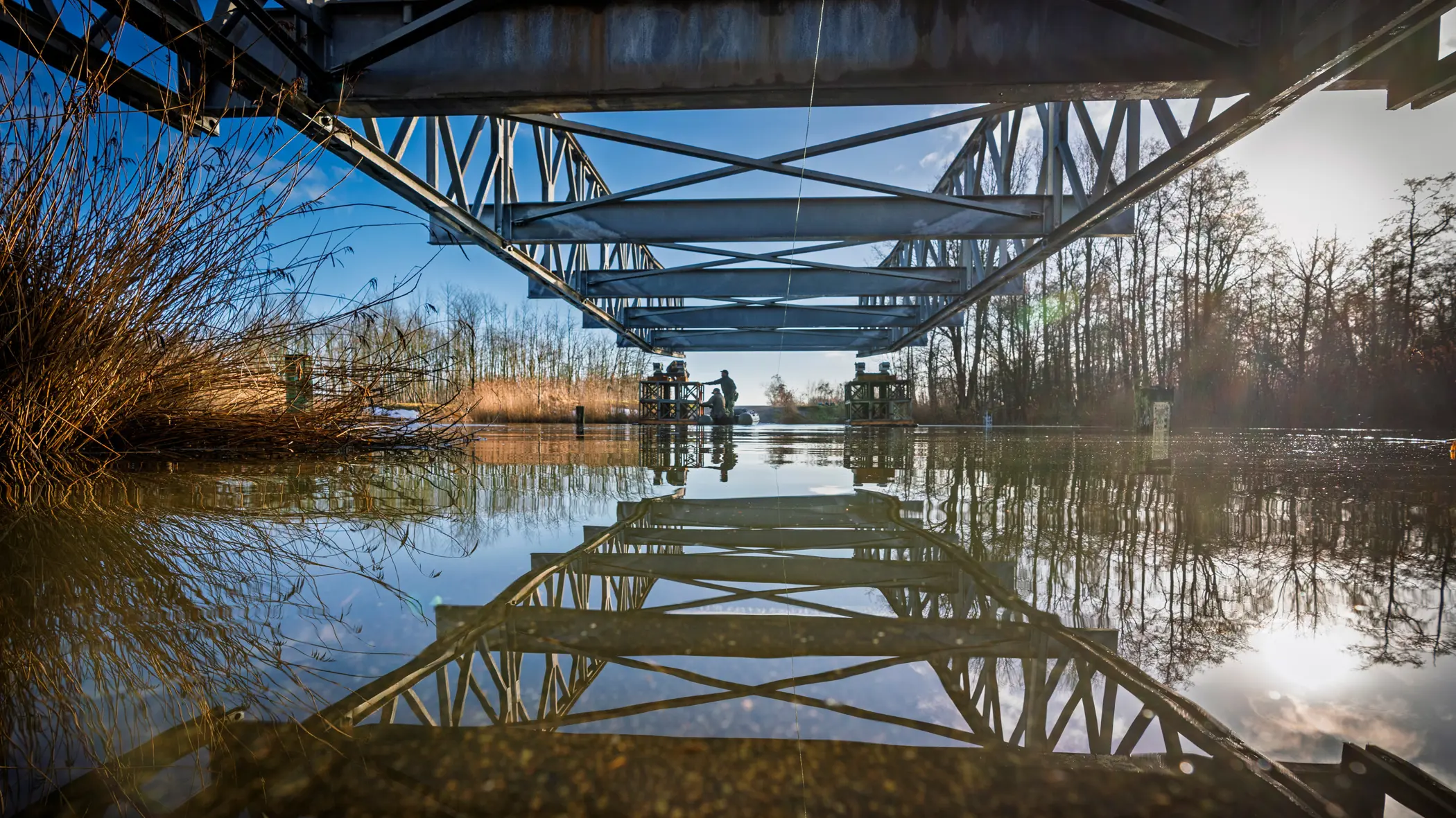 De constructiegenie legt een brug aan over het water.