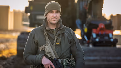 Een militair met zijn wapen voor de borst.