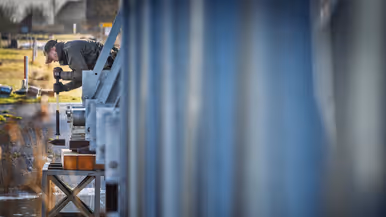 Een militair bouwt aan een deel van een brug.