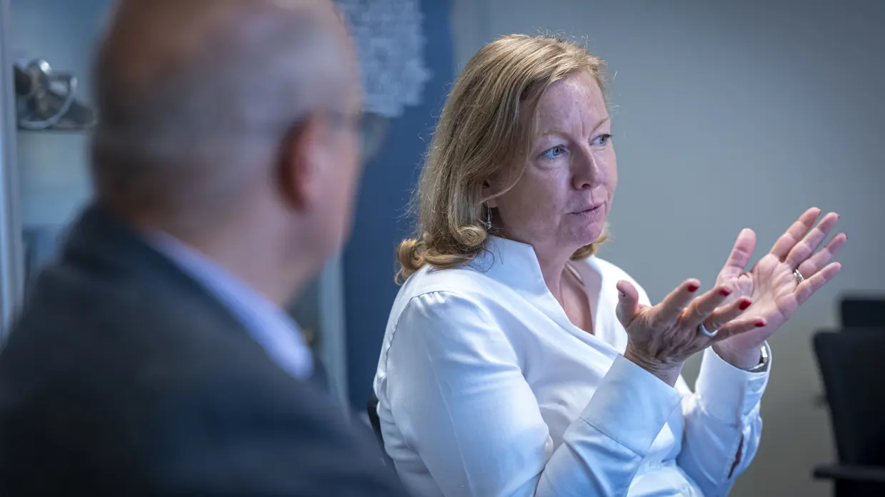 Een vrouw gebruikt haar handen tijdens een gesprek. 