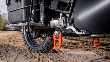 Close-up van de oranje haken die aan de voetsteunen bevestigd zijn.