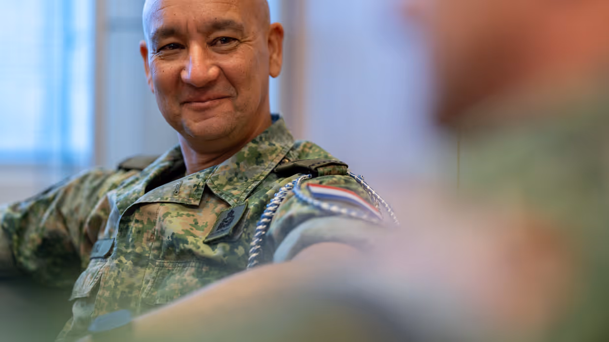 Luchtmachtadjudant Johan de Rooij kijkt vrolijk in de richting van oud-Luchtmachtadjudant Terry Venhovens tijdens het interview. 