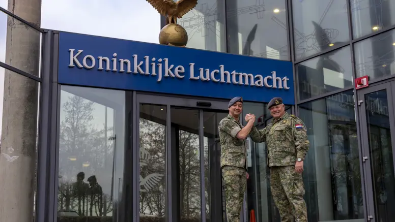  Luchtmachtadjudanten Terry Venhovens en Johan de Rooij schudden elkaar de hand voor de ingang van de Luchtmachttoren in Breda.