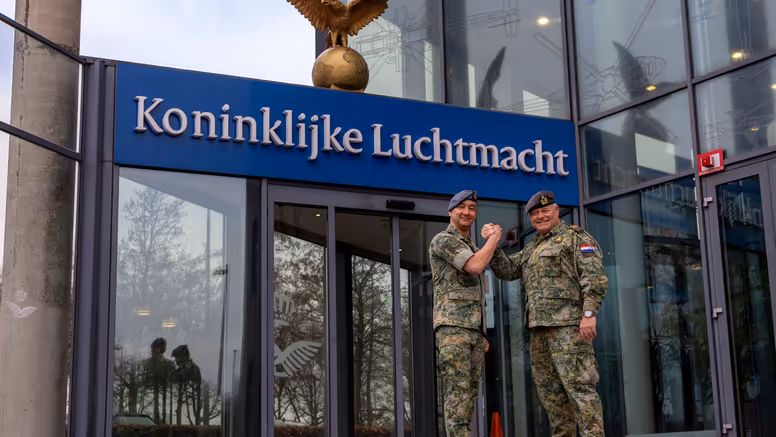  Luchtmachtadjudanten Terry Venhovens en Johan de Rooij schudden elkaar de hand voor de ingang van de Luchtmachttoren in Breda.
