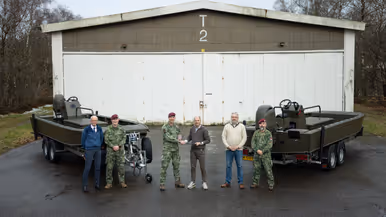 Twee boten, een handvol mannen en de overhandiging van een schildje van de eenheid.