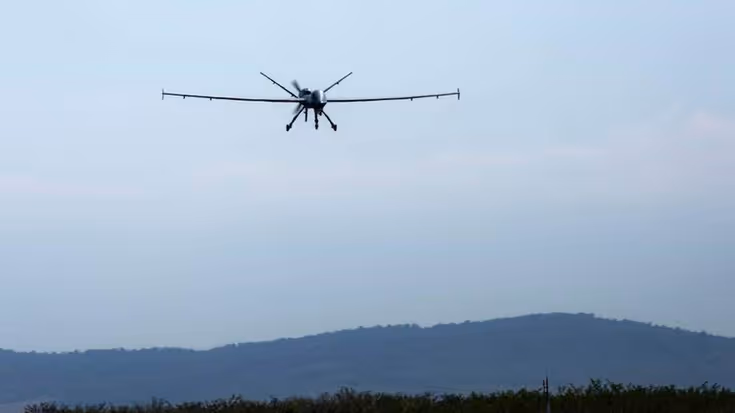 MQ-9 Reaper in de lucht, boven heuvelachtig terrein