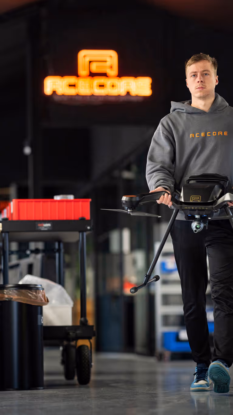 Een medewerker van Acecore loopt door de werkruimte met een drone.