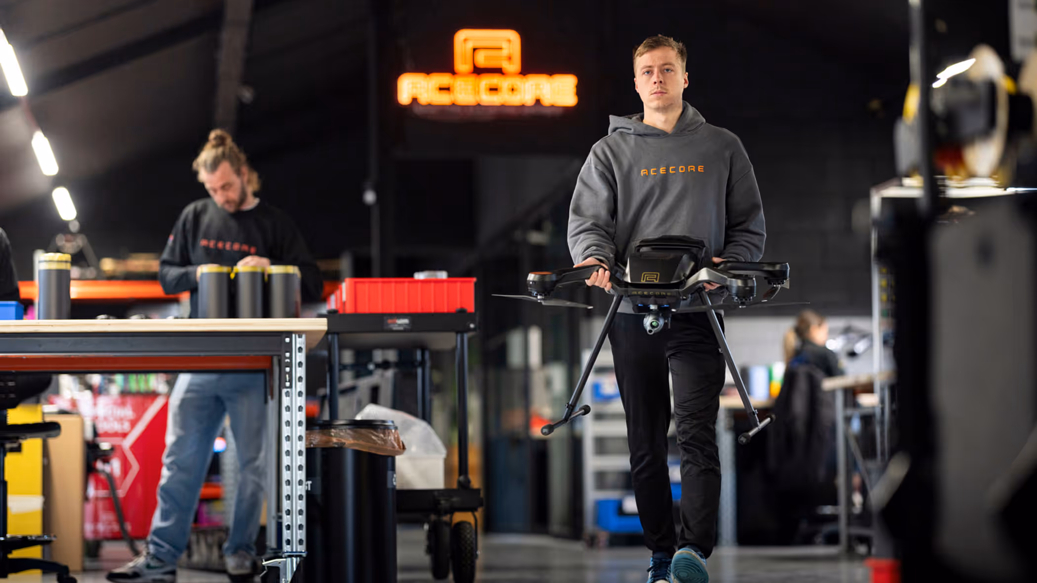 Een medewerker van Acecore loopt door de werkruimte met een drone.