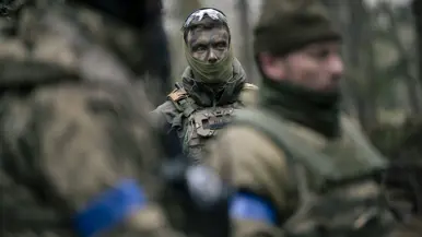 Luitenant Bas op de achtergrond en op de voorgrond onscherpe Oekraïense militairen. 