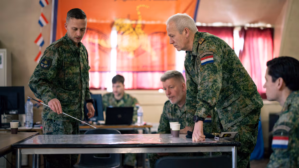 Een militair praat andere militairen bij over een training. 