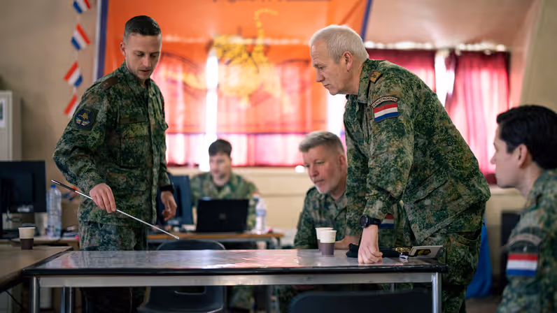 Een militair praat andere militairen bij over een training. 