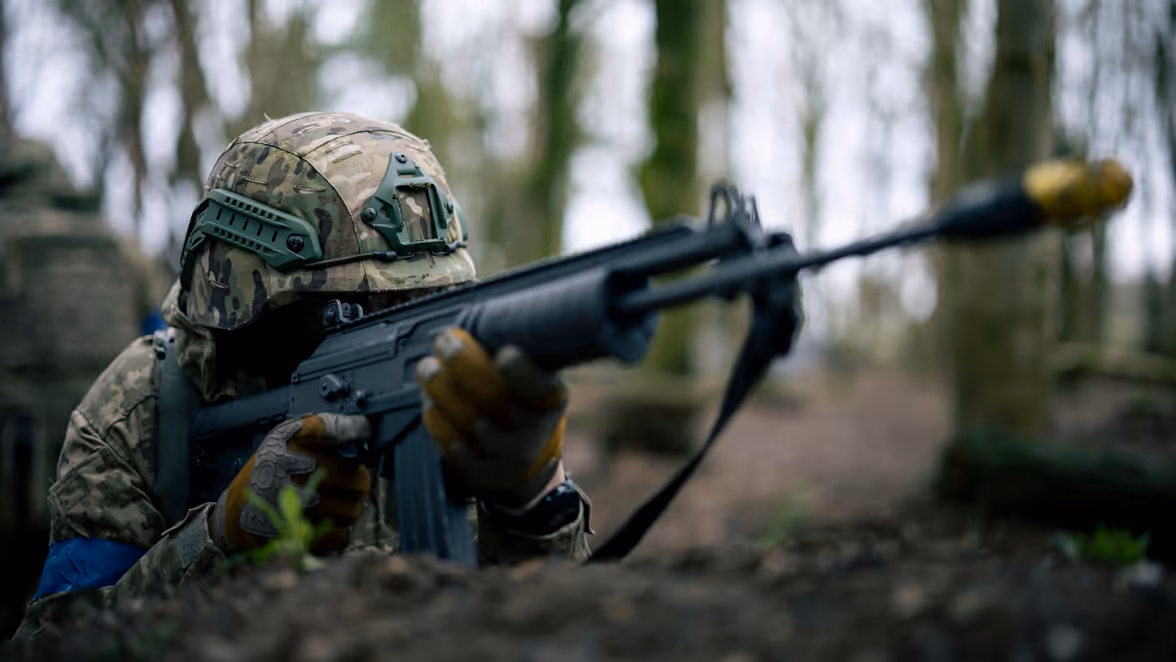 Een militair richt zijn wapen.