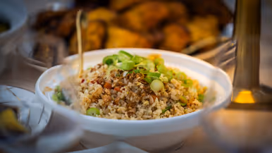 Overzicht van een tafel met eten, met mensen in uniform rondom. 