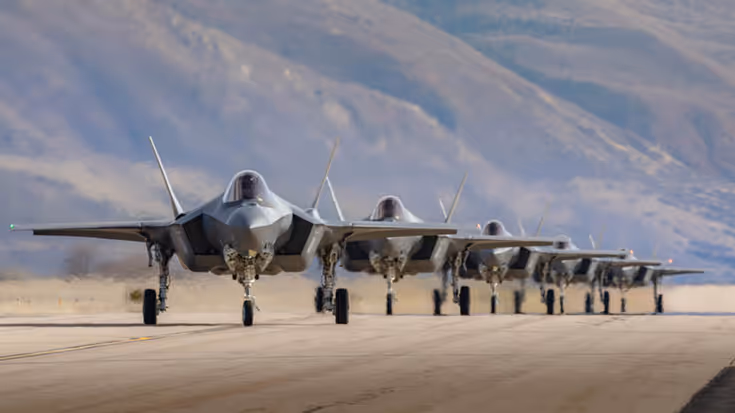 5 F-35's op een rij met op de achtergrond een berghelling.