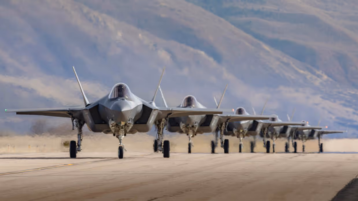 5 F-35's op een rij met op de achtergrond een berghelling.