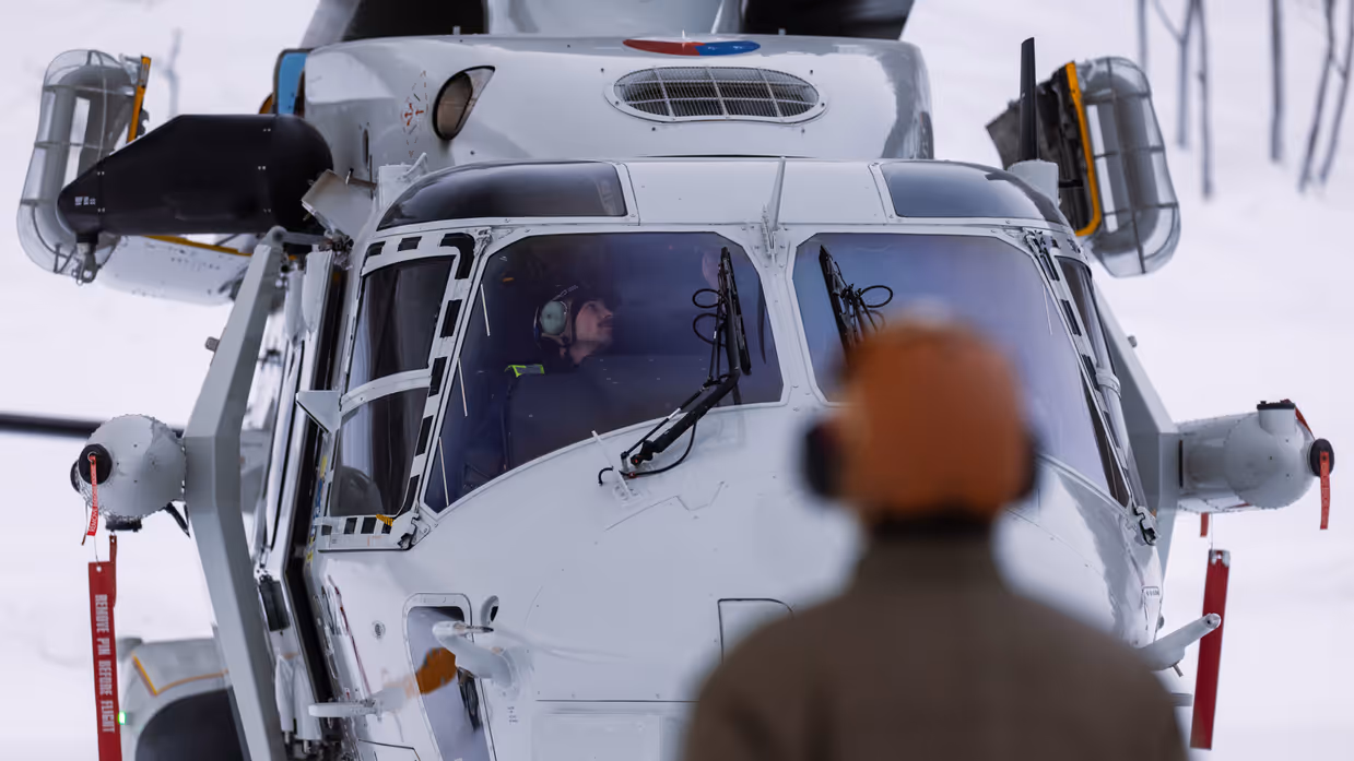 NH90 van het maritieme helikoptersquadron op een besneeuwd vliegveld in Noorwegen tijdens oefening Cold Response, met bemanningsleden zichtbaar in de cockpit.