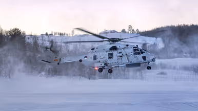 NH90 van het maritieme helikoptersquadron op een besneeuwd vliegveld in Noorwegen tijdens oefening Cold Response, met bemanningsleden zichtbaar in de cockpit.