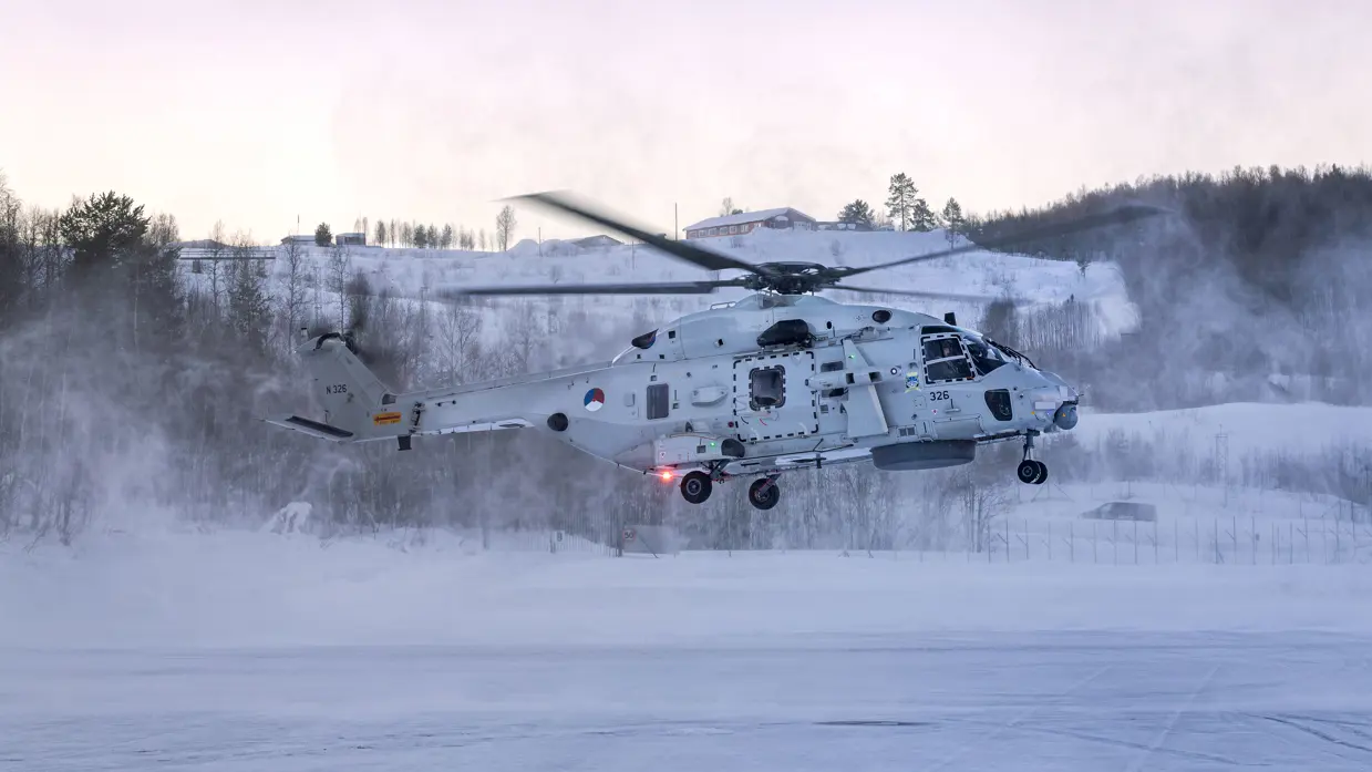 NH90 van het maritieme helikoptersquadron op een besneeuwd vliegveld in Noorwegen tijdens oefening Cold Response, met bemanningsleden zichtbaar in de cockpit.