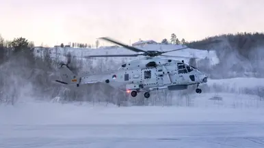 NH90 van het maritieme helikoptersquadron op een besneeuwd vliegveld in Noorwegen tijdens oefening Cold Response, met bemanningsleden zichtbaar in de cockpit.