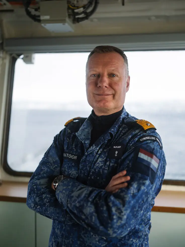 Commandeur Pastoor in boordtenue op de brug van de Johan de Witt. 
