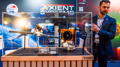 Links staat een man achter een vitrine waarin een schaalmodel is te zien van een satelliet. Op de andere foto is een schaalmodel van een andere satelliet te zien met gouden bekleding.