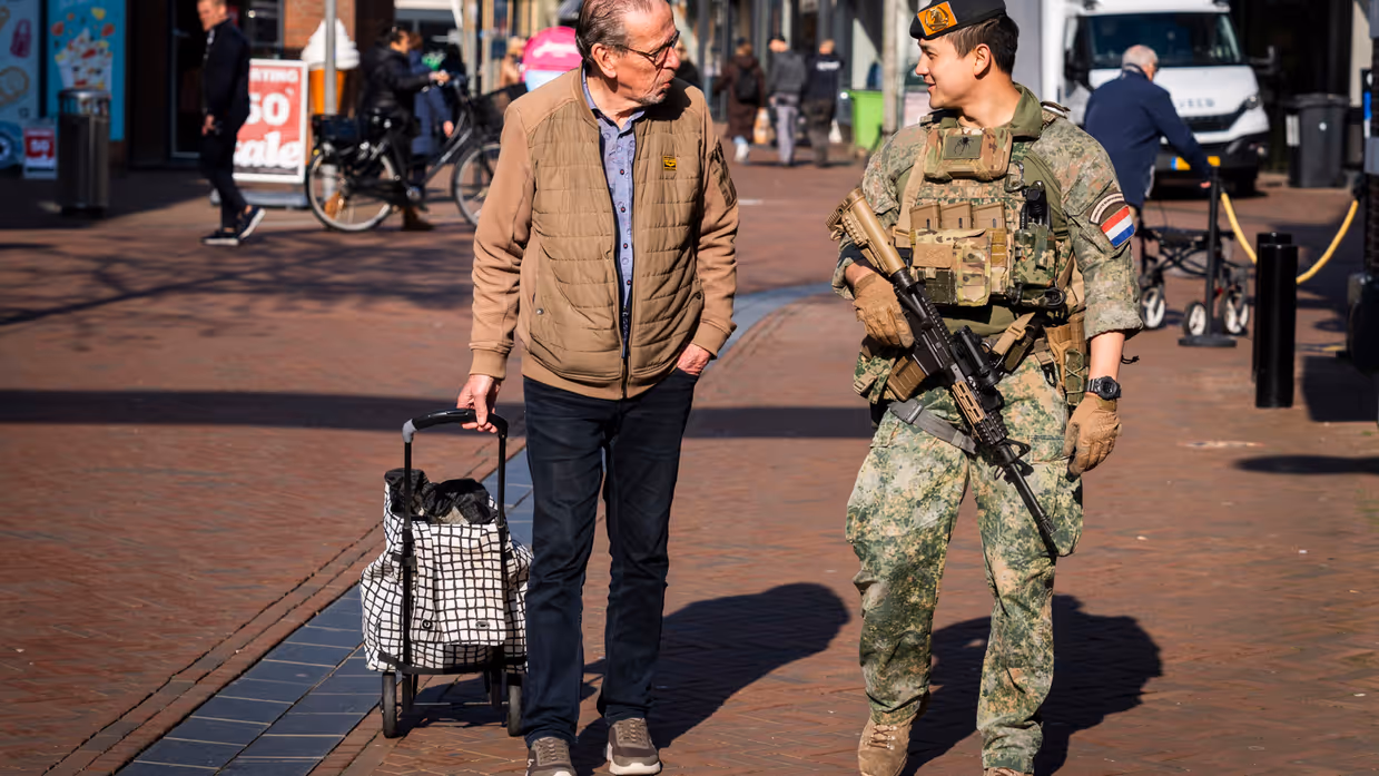 Een militair en een burger in gesprek in de stad. 