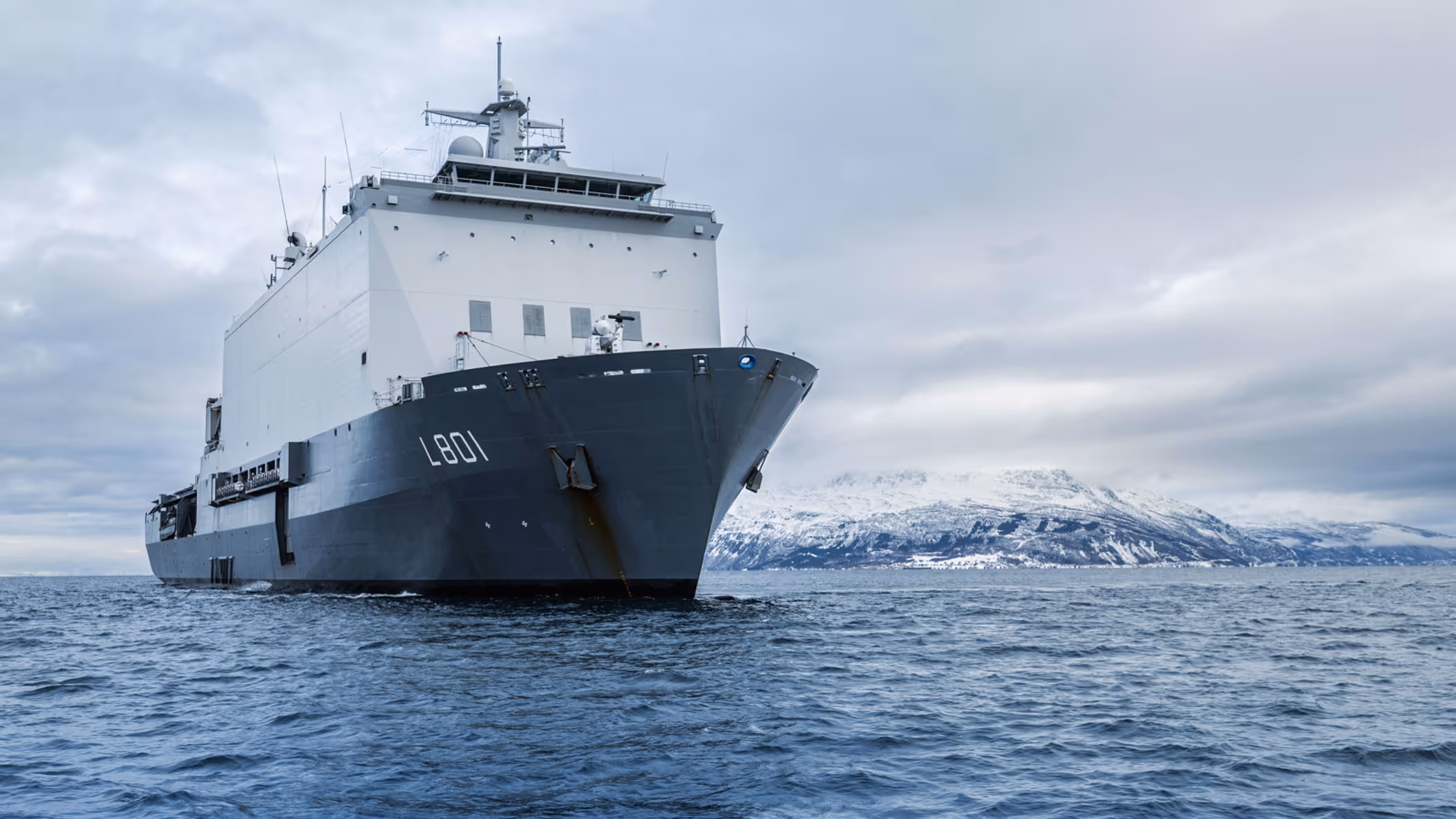 Zr.Ms. Johan de Witt vaart langs een besneeuwde Noorse kust tijdens oefening Cold Response. 
