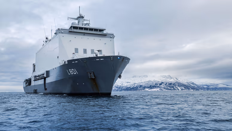 Zr.Ms. Johan de Witt vaart langs een besneeuwde Noorse kust tijdens oefening Cold Response. 