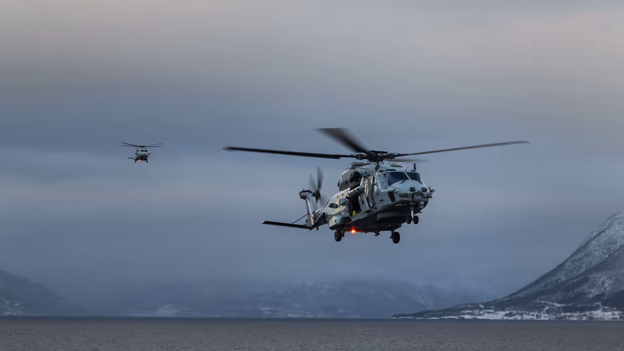 Twee NH90’ van 860 Squadron landen op het vliegdek van Zr.Ms. Johan de Witt tijdens oefening Cold Response in een besneeuwd Noors fjord.