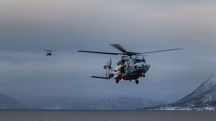 Twee NH90’ van 860 Squadron landen op het vliegdek van Zr.Ms. Johan de Witt tijdens oefening Cold Response in een besneeuwd Noors fjord.