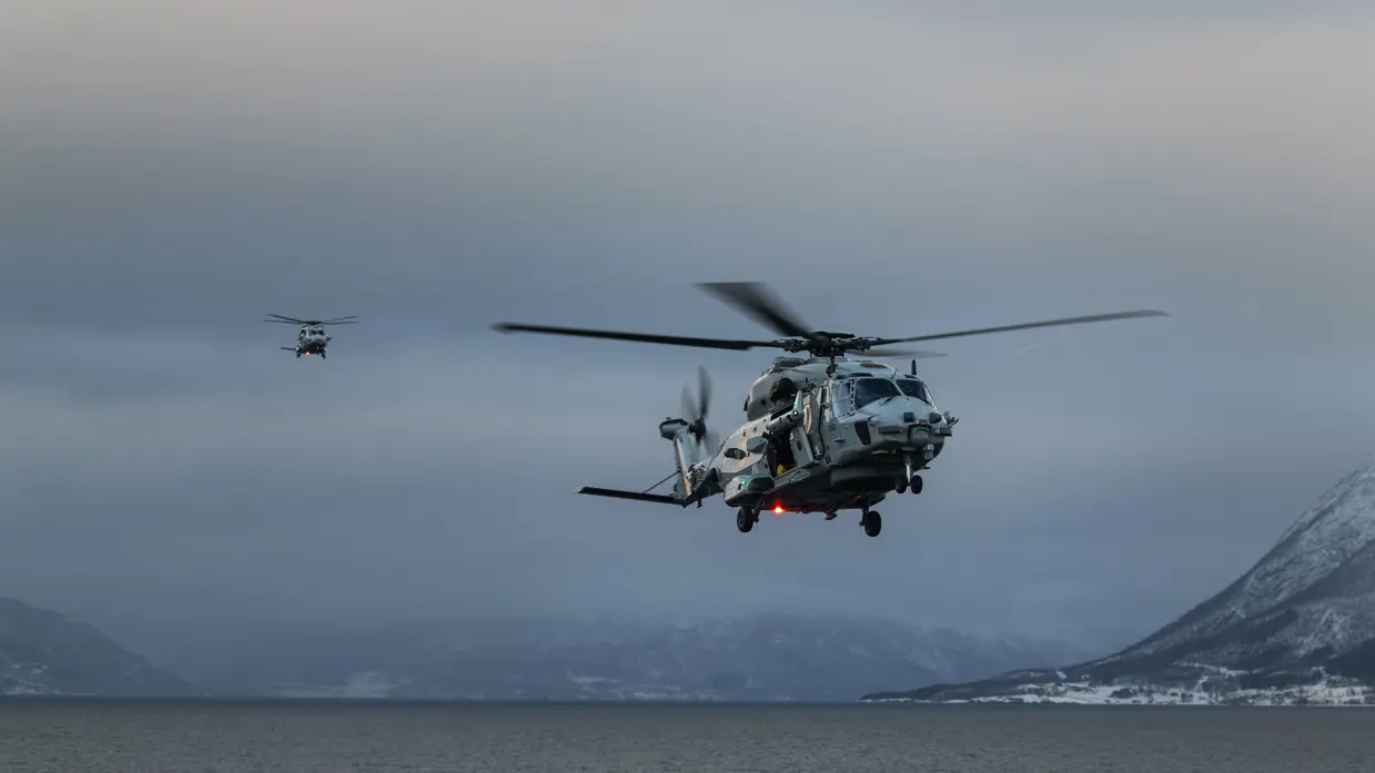 Twee NH90’ van 860 Squadron landen op het vliegdek van Zr.Ms. Johan de Witt tijdens oefening Cold Response in een besneeuwd Noors fjord.