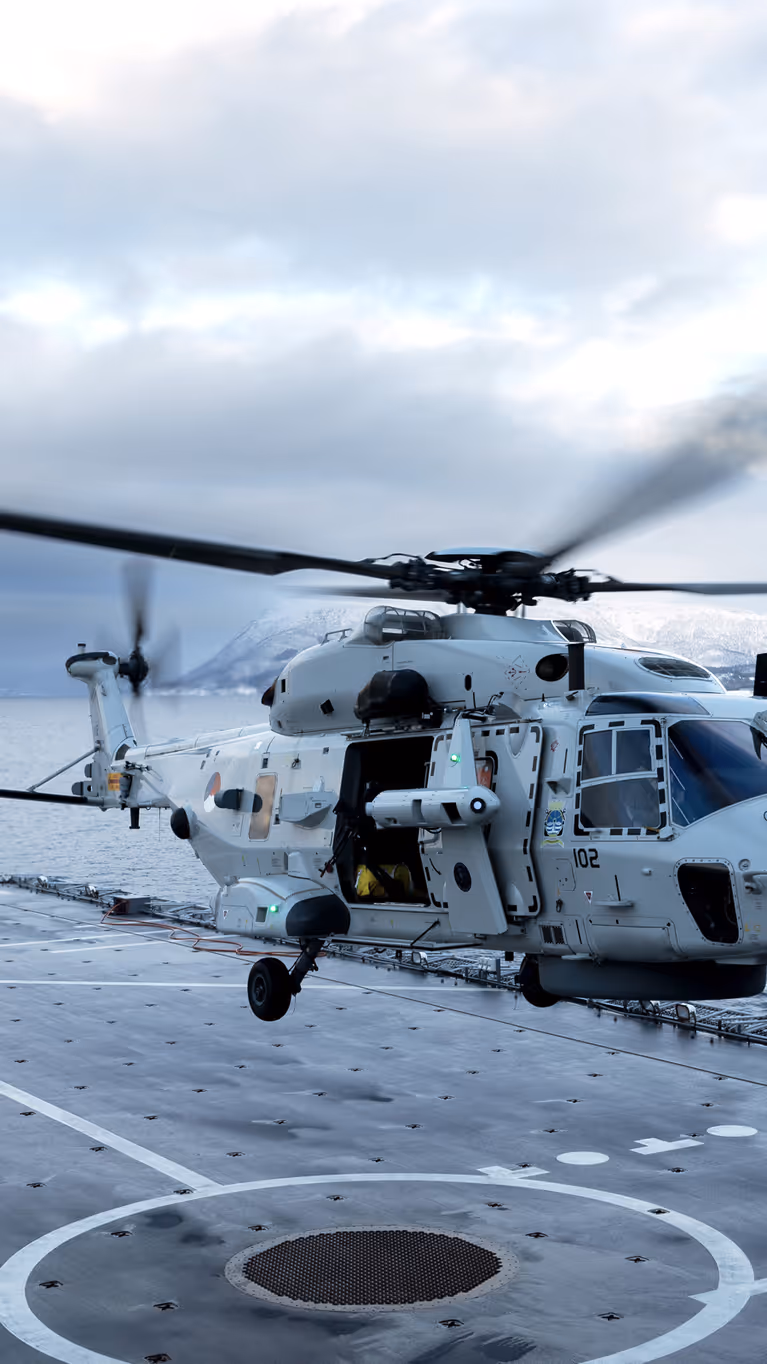 Een NH90 landt op het helikopterdek van een schip.