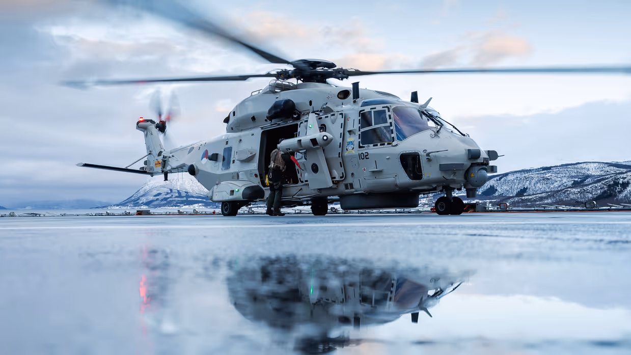 Een NH90 weerspiegelt in het smeltwater op het vliegdek van Zr.MS.Johan de Witt.