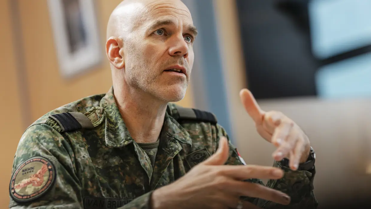 Commodore Jeroen van Bruchem zit, in militair uniform, aan een tafel en praat. Daarbij maakt hij gebruik van zijn handen.