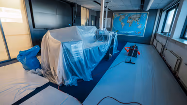 Vier foto’s van werkzaamheden. Naast een kantoorruimte met afgedekte bureaus, laptops en toetsenborden gaat het om een kabel die uit het plafond hangt. Tot slot het logo van de luchtmacht tegen een muur, daarnaast een afgedekt beeldscherm.