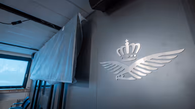 Vier foto’s van werkzaamheden. Naast een kantoorruimte met afgedekte bureaus, laptops en toetsenborden gaat het om een kabel die uit het plafond hangt. Tot slot het logo van de luchtmacht tegen een muur, daarnaast een afgedekt beeldscherm.