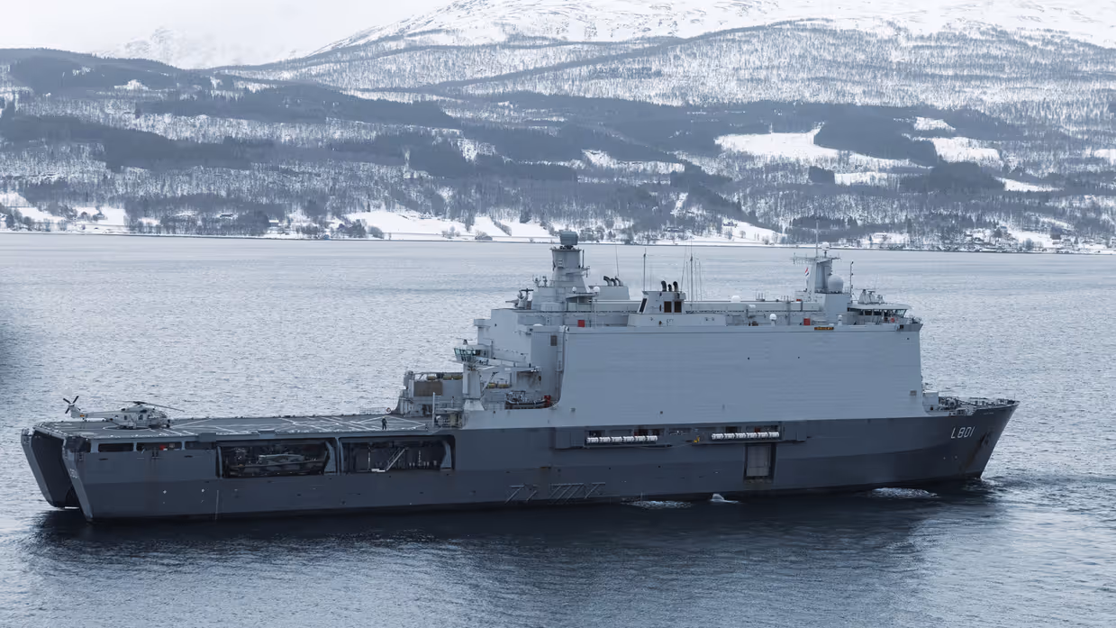 NH90-helikopter van 860 Squadron op een nat vliegdek in Noorwegen tijdens oefening Cold Response, met besneeuwde bergen op de achtergrond.