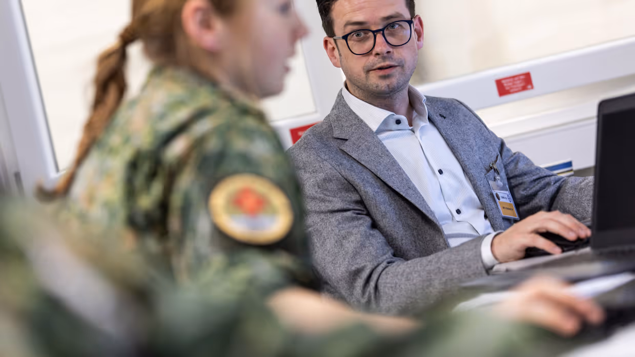 Ambtenaar en  militair met elkaar in gesprek.