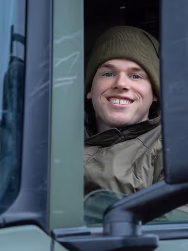 Een lachende soldaat in een vrachtwagen. 