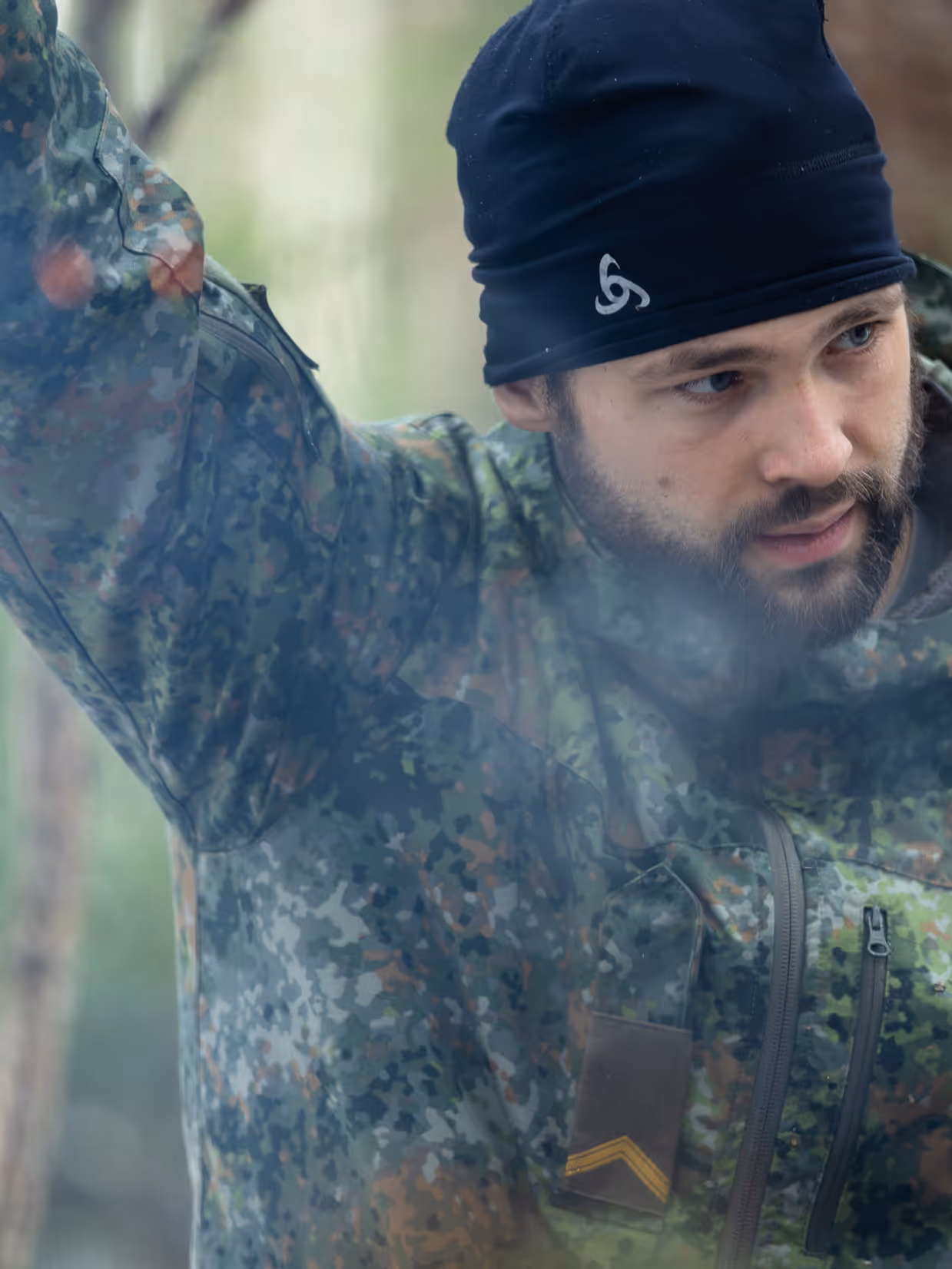 Portret van sergeant Patrick kijkt toe hoe zijn groep een vuurtje probeert te maken.