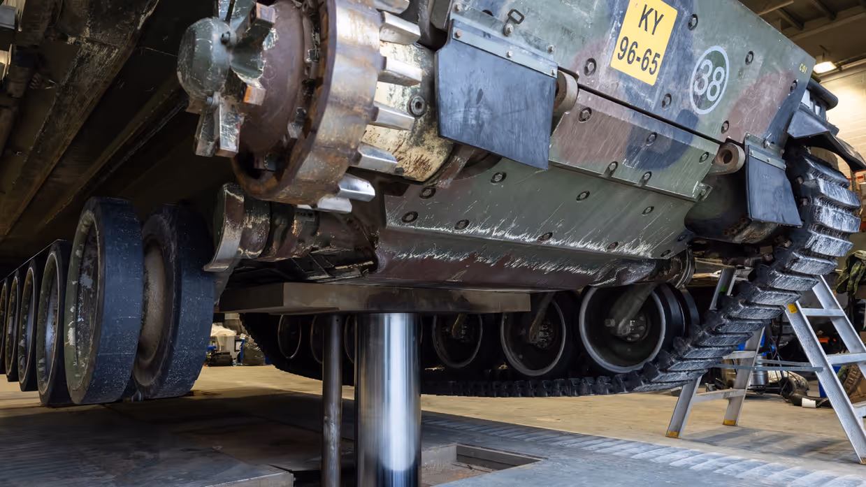  Een militair voertuig staat op een metalen paal.